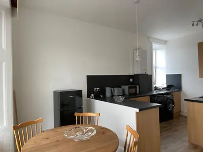 a kitchen with a wooden table with chairs and a counter at Spacious 3 bedroom apartment in Campbeltown centre in Campbeltown