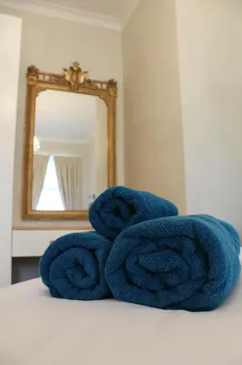 a pile of towels sitting on a bed in front of a mirror at The Dower House at Solsgirth Home Farm in Dollar