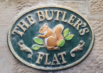 a sign with a squirrel on the side of a building at The Butler's Flat at Solsgirth Home Farm in Dollar