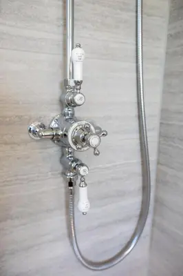 a shower with a hose attached to a wall at The Butler's Flat at Solsgirth Home Farm in Dollar