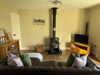 a living room with a couch and a wood stove at The Loch Lomond But n Ben in Gartocharn