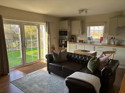 a living room with a couch and a kitchen at The Loch Lomond But n Ben in Gartocharn