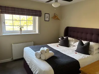 a bedroom with two beds with towels on them at The Loch Lomond But n Ben in Gartocharn