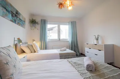 a bedroom with two beds and a window at Ideal Contractor Stay 2-Bed Near Glasgow Fort in Garthamlock