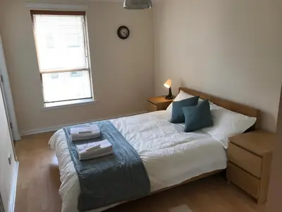 a bedroom with a bed with a blue blanket at Apartment in Heart of West End- Parking Space- Spacious- Near Glasgow University and Kelvingrove Art Gallery in Glasgow