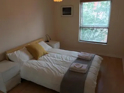 a bedroom with a bed with two towels on it at Apartment in Heart of West End- Parking Space- Spacious- Near Glasgow University and Kelvingrove Art Gallery in Glasgow