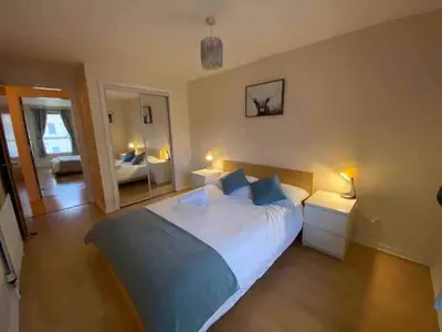 a bedroom with a large bed and a mirror at Apartment in Heart of West End- Parking Space- Spacious- Near Glasgow University and Kelvingrove Art Gallery in Glasgow