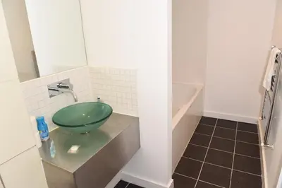 a bathroom with a green bowl sink on a counter at Glasgow Hydro Apt with Great Views in Glasgow
