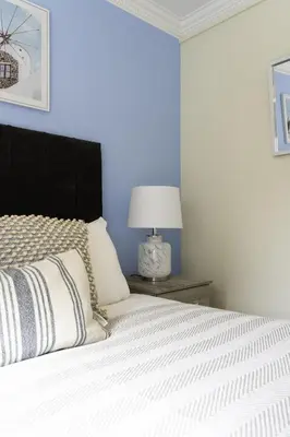 a bedroom with a bed with a black headboard and a lamp at Riverview House in Glasgow