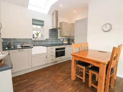 a kitchen with a wooden table and a dining room at The Old House, Balure in Oban