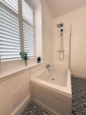 a white bathroom with a tub and a window at Bay View Cottage in Fairlie