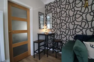 a living room with a table and a door at Links Cottage, Prestwick in Prestwick