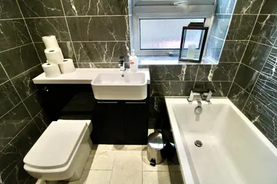 a bathroom with a sink and a toilet and a tub at Links Cottage, Prestwick in Prestwick