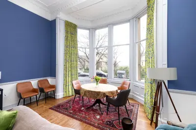 a living room with a table and chairs at JOIVY Spacious 2-Bedroom Ground Floor Flat in Edinburgh