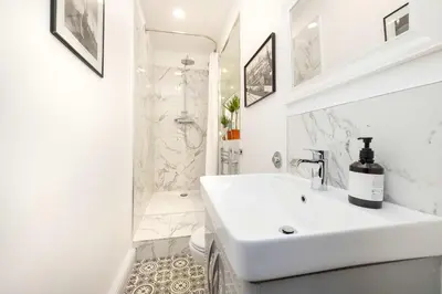 a white bathroom with a sink and a shower at JOIVY Spacious 2-Bedroom Ground Floor Flat in Edinburgh