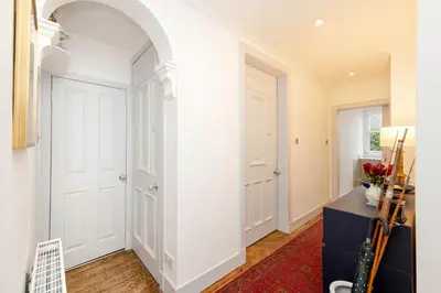 a hallway with a white door and a red rug at JOIVY Spacious 2-Bedroom Ground Floor Flat in Edinburgh