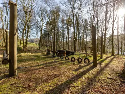 a fence with a horse pulling a cart in a field at Holiday Home Foxglove cottage by Interhome in Straiton