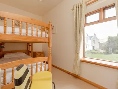 a bedroom with a bunk bed and a window at Holiday Home Foxglove cottage by Interhome in Straiton