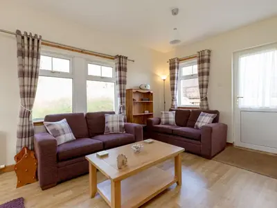 a living room with two couches and a coffee table at Holiday Home Foxglove cottage by Interhome in Straiton