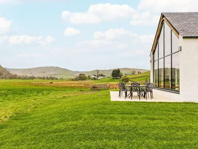a group of tables and chairs in a field at Holiday Home Balbeg Cottage by Interhome in Straiton