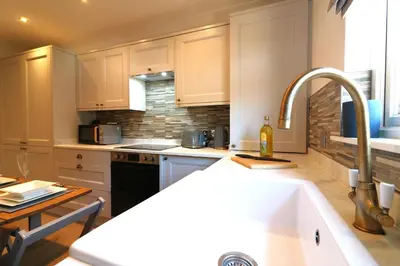 a kitchen with white cabinets and a sink at Signature - Cross House in Lanark