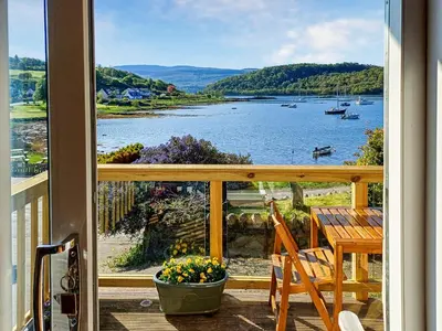 a balcony with a view of a lake at Ardtornish Apartment in Tayvallich