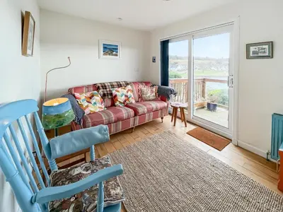 a living room with a couch and a balcony at Ardtornish Apartment in Tayvallich