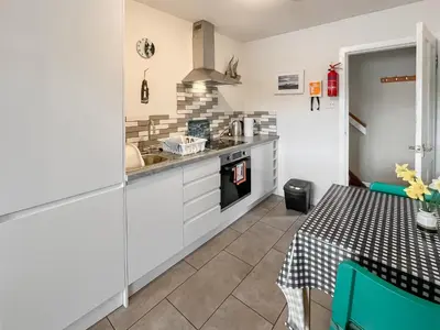 a kitchen with a table and a sink and a stove at Ardtornish Apartment in Tayvallich