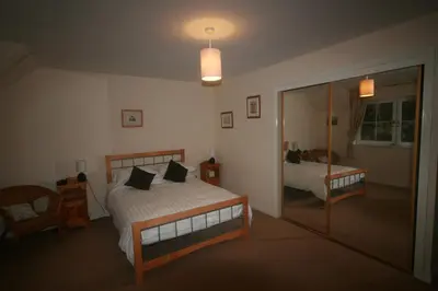 a bedroom with a bed and a mirror at Stonewater House Vegan Bed and Breakfast in Lamlash