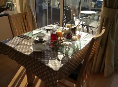 a dining room table with a table cloth on it at Stonewater House Vegan Bed and Breakfast in Lamlash