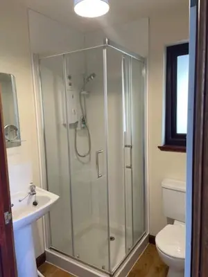 a bathroom with a shower and a sink and a toilet at The Roost in Appin