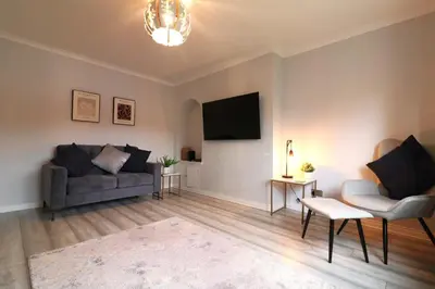 a living room with a couch and a tv at Signature - Drumvale House in Chryston