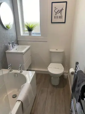 a bathroom with a sink and a toilet and a window at Glen Mhor - Beautiful two bedroom apartment Dunfermline in Townhill