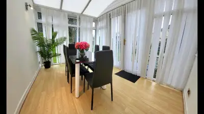 a dining room with a table with chairs and flowers at Home to Home in Glasgow