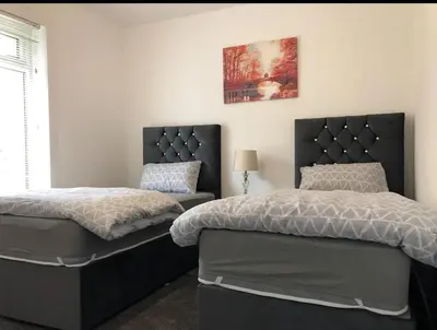 a bedroom with two beds and a window at Home to Home in Glasgow