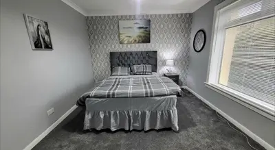 a bedroom with a bed in the corner of a room at Home to Home in Glasgow
