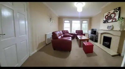 a living room with a red couch and a fireplace at Home to Home in Glasgow