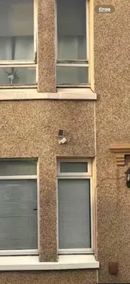 two windows on the side of a brick building at Home to Home in Glasgow