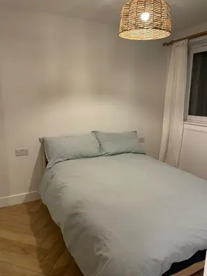 a bedroom with a white bed with a chandelier at 2 Bed on the Glasgow Green in Glasgow