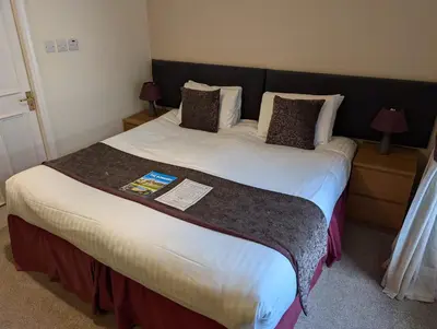 a bed in a hotel room with a large bed sidx sidx sidx at Gordon Arms Hotel in West Linton
