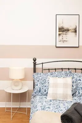 a bedroom with a bed with a blue and white bedspread at Vacant Nests The Milton Dunfermline Parking in Dunfermline