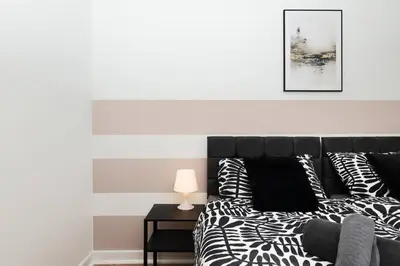 a bedroom with a bed with black and white pillows at Vacant Nests The Milton Dunfermline Parking in Dunfermline