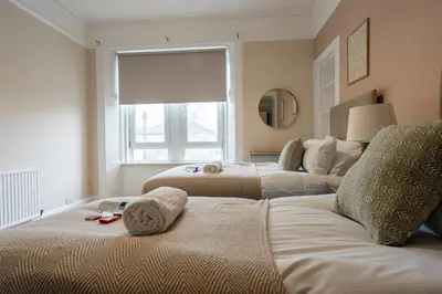 a bedroom with two beds with towels on them at Station Road Stays in Hartwood