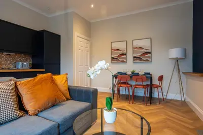 a living room with a blue couch and a table at Station Road Stays in Hartwood