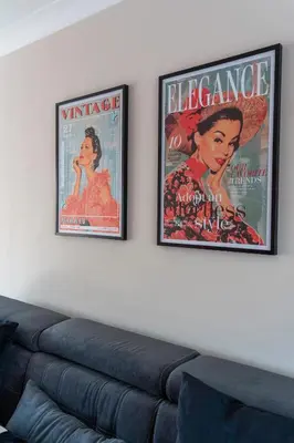 two posters on a wall above a couch at Beauly Court Suites in Grangemouth