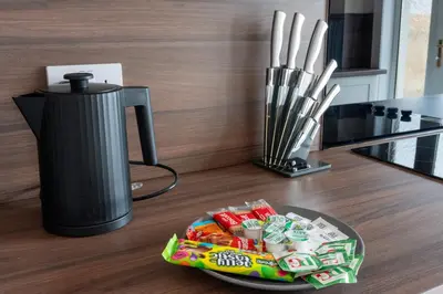 a plate of candy on a table next to a blender at Beauly Court Suites in Grangemouth