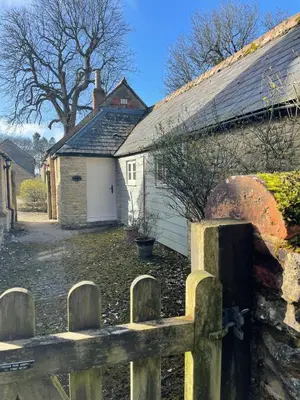 a house with a fence in front of it at Quaint Oxfordshire cottage on a peaceful farm in Moffat