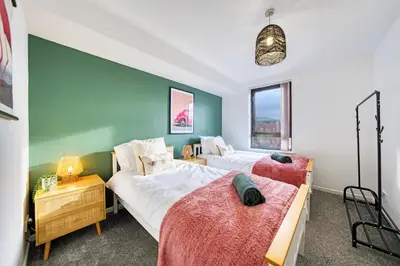 two beds in a bedroom with a green wall at 2BR Flat with Free Parking in Central Location in Glasgow