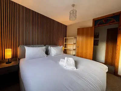 a bedroom with a large white bed with two towels on it at The Maltings Retreat in Inverkeithing