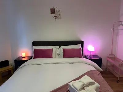 a bedroom with a large bed with pink lighting at Private main door Two Bedrooms Apartment in Edinburgh